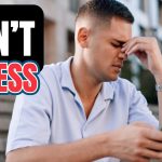 A man sitting on outdoor steps, looking stressed while holding a phone, with bold overlaid text that reads: “DON’T STRESS.”