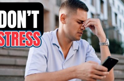 A man sitting on outdoor steps, looking stressed while holding a phone, with bold overlaid text that reads: “DON’T STRESS.”